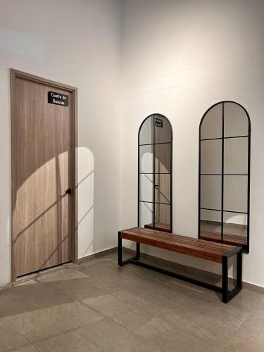 a room with two mirrors and a bench next to a door at BIT by Simple stay in Medellín