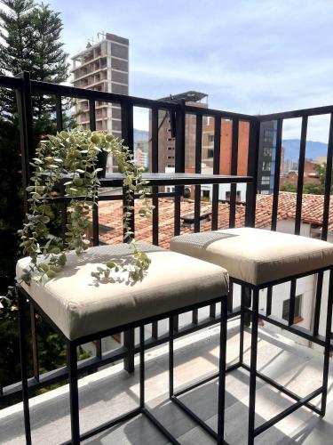 a balcony with two chairs and a potted plant on it at BIT by Simple stay in Medellín
