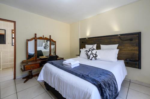 a bedroom with a large bed and a mirror at Seagull Villa in Margate