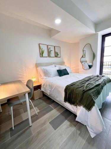 a bedroom with a bed and a table and a desk at BIT by Simple stay in Medellín