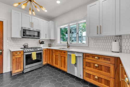 a kitchen with white cabinets and a stove at The Exquisite Villa by Granger Gardens in Ann Arbor