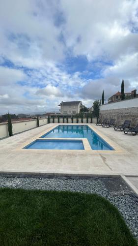 a swimming pool with chairs and a building at Casa Laurinda- Casa Inteira Marco de Canaveses in Marco de Canaveses