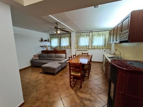 Una cocina y una sala de estar con una mesa y un sofá. en Barbara House, en Tribiano