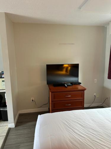 a bedroom with a bed and a flat screen tv at Travelodge by Wyndham Langley in Langley