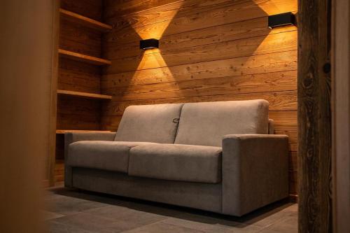 een bank in een kamer met houten wanden bij Appartement dans le Mercantour - accès PMR - in Saint-Étienne-de-Tinée