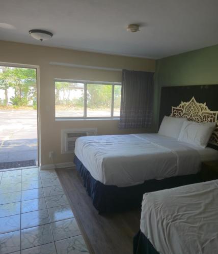 ein Schlafzimmer mit zwei Betten und einem großen Fenster in der Unterkunft Nashoba Valley Inn & Suites in Ayer