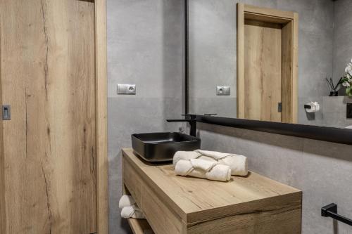 a bathroom with a sink and towels on a counter at Orava Horizont - Jollien Apartments in Námestovo