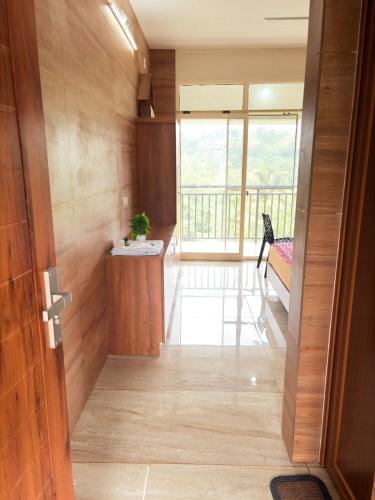 a hallway of a house with a large window at Cozy meadows homestays in Anachal