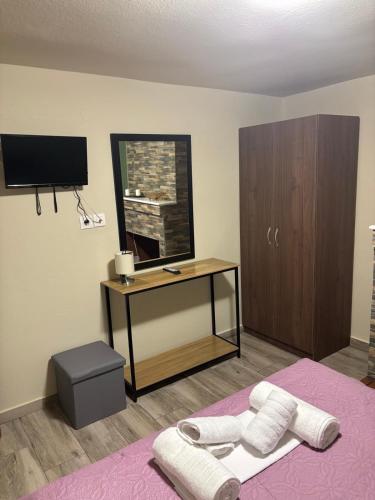 a bedroom with a bed with a desk and a tv at Central House in kastraki in Mesochórion