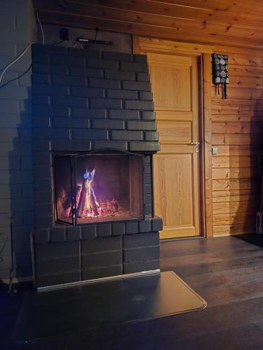 a brick fireplace with a fire in it at Ylläs Valokki in Ylläsjärvi