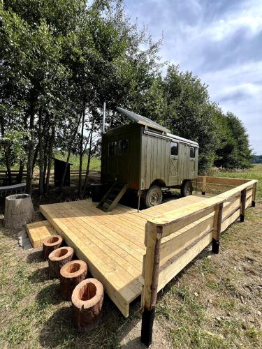 an rv is parked on a wooden platform with logs at Maringotka Kuba 