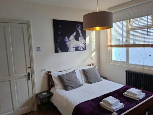 a bedroom with a bed with a purple blanket at Ground floor double with en suite shower room in Brighton & Hove