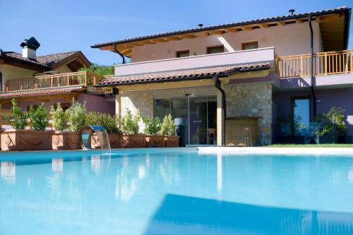 a swimming pool in front of a house at Agriturismo Vin e Amor in Dro