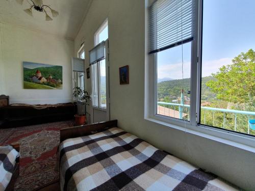 a bedroom with a bed and a large window at Sweet Home 2 in Dilijan