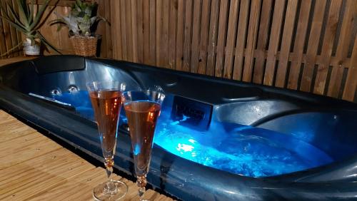 two champagne glasses sitting in a blue tub at Dream cube & Spa in Coutevroult