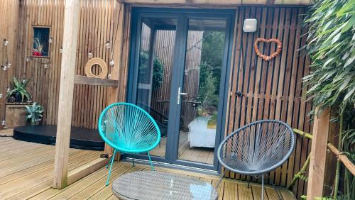 two blue chairs sitting on a wooden deck at Dream cube & Spa in Coutevroult