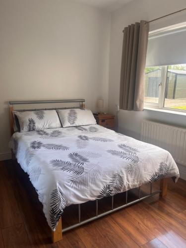 a bed with a white comforter and a window at Countryside Family Home in Balrath