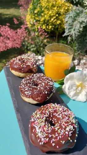 two donuts on a tray next to a glass of orange juice at Dream cube & Spa in Coutevroult