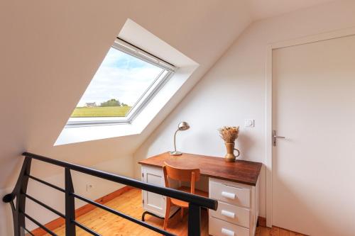 an attic room with a desk and a window at Jolie longère près de Pontrieux in Ploëzal