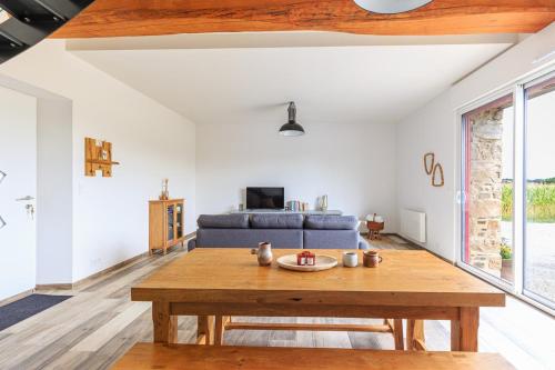 a living room with a blue couch and a wooden table at Jolie longère près de Pontrieux in Ploëzal