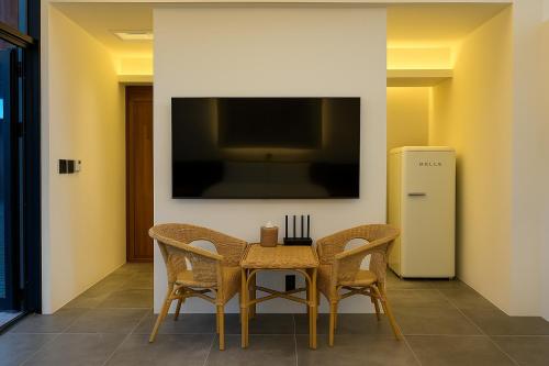 a dining room with a table and chairs and a television at Jeju Dodu Tropical Premium Pool Villa in Jeju
