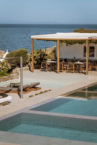 a resort with a swimming pool and a pavilion at Mykonos Soul Luxury Suites in Agios Stefanos
