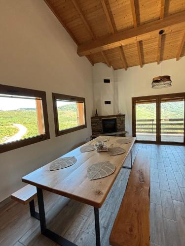 a large wooden table in a room with windows at Casa da Tapada Santo Antonio in Branda de Santo António