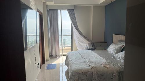 a bedroom with a bed and a large window at Sea View Apartment in Colombo -Dehiwala in Dehiwala