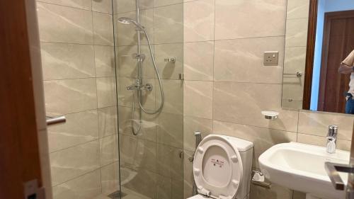 a bathroom with a shower and a toilet and a sink at Sea View Apartment in Colombo -Dehiwala in Dehiwala