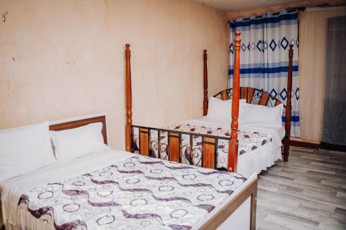 two beds are in a room withthritisthritisthritisthritisthritisthritisthritisthritisthritis at Spice Nest Resort in Kangaru
