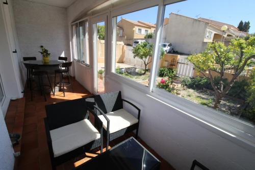un balcone con due sedie e un tavolo e due finestre di Villa l'Oranger a Sigean