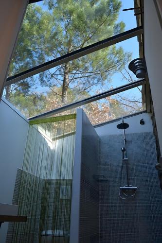une salle de bain avec douche avec une grande fenêtre dans l'établissement Gite Familial de caractère, à Châteauneuf-de-Bordette