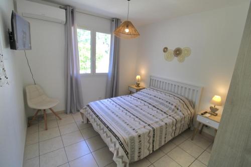 una camera da letto con un letto, una scrivania e una finestra di Villa l'Oranger a Sigean