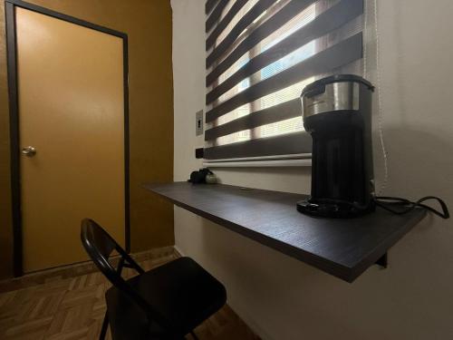 a black blender sitting on a shelf next to a window at Hotel Colonial in Escárcega