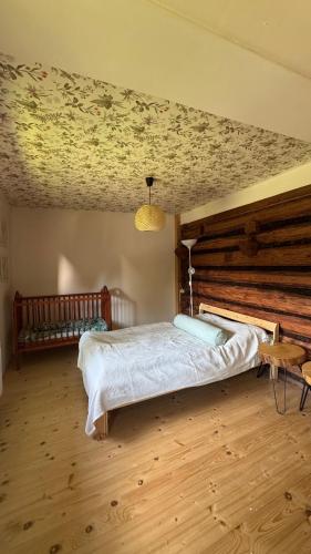 a bedroom with a bed and a wooden floor at Chatka na Lipowych Wzgórzach in Marcówka