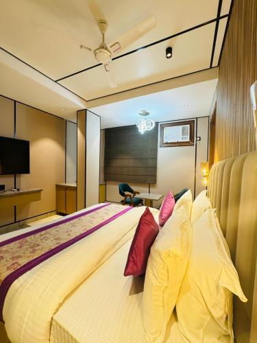 a bedroom with a large bed with pillows at JS Residency Luxe Collection Hotel Near Nizamuddin Railway Station in New Delhi