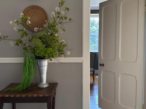 a vase of flowers on a table next to a door at The Almanage in Clogheen