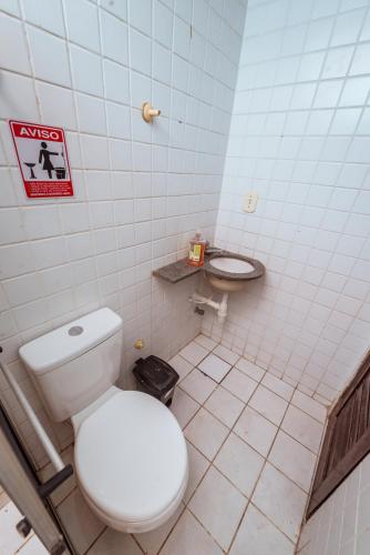 a bathroom with a white toilet and a sink at Casa c 4 suites, Piscina, Churrasqueira e Garagem in Cabedelo