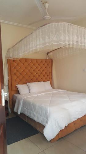 a bedroom with a white bed with a white bedspread at Rose homes in Mombasa