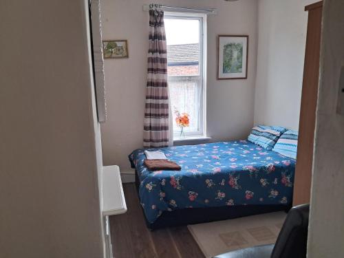 a small bedroom with a bed and a window at Bright Home Guest House in Manchester