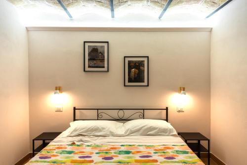 a bedroom with a bed and two pictures on the wall at Le Coste in Villetta Barrea