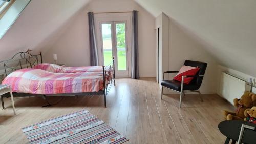 ein Schlafzimmer mit einem Bett und einem Stuhl in der Unterkunft UNESCO de Beemster, vakantiewoning in Noordbeemster