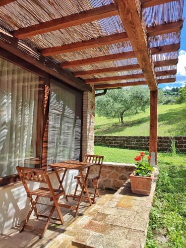 a patio with two chairs and a wooden pergola at CasalPiano in Orvieto