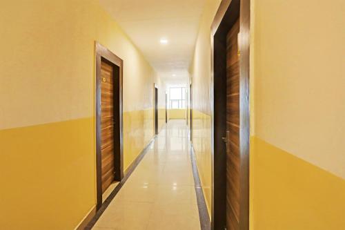 a hallway with yellow walls and a long corridor at Capital O Saharsh Grand Near Shilparamam in Hyderabad