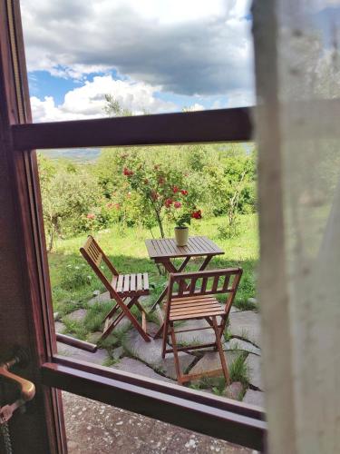 a table and chairs on a porch with a table and flowers at CasalPiano in Orvieto