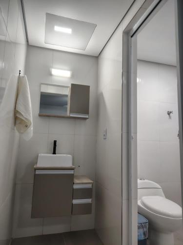 ein weißes Badezimmer mit Waschbecken und Toilette in der Unterkunft Casa do Sol III in Peruíbe