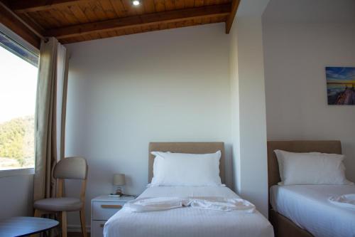a bedroom with two beds and a window at The Horizon in Berat