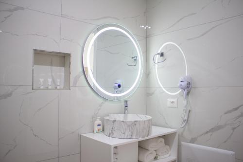 a white bathroom with a sink and a mirror at The Horizon in Berat