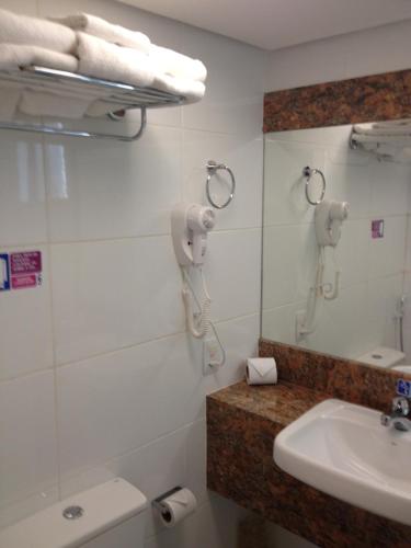 a bathroom with a sink and a phone on the wall at Hotel Diogo in Fortaleza