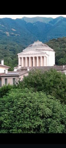a large white building in front of a mountain at B&B Santa Fosca in Pederobba